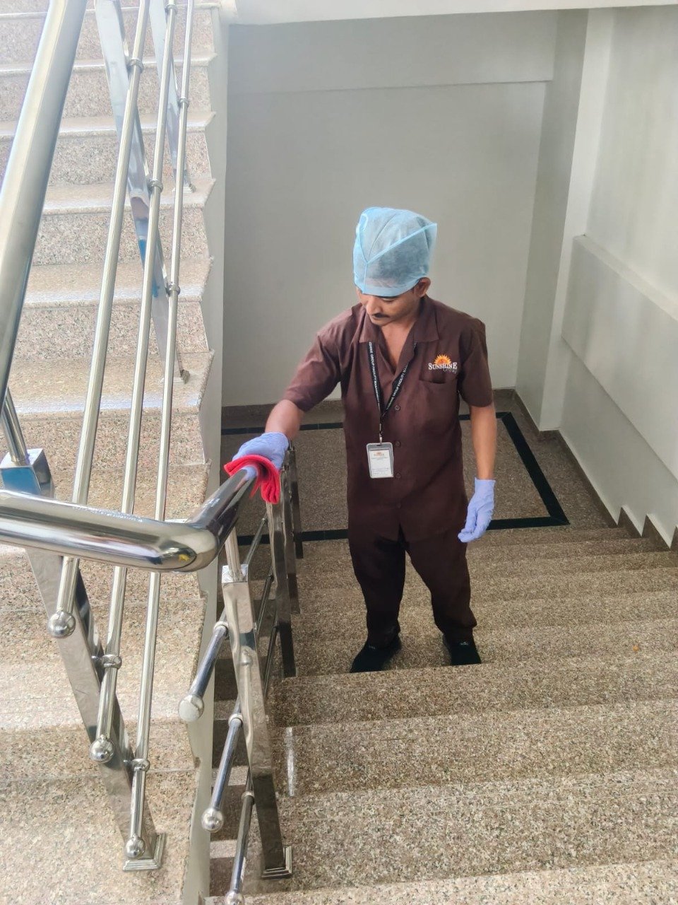 Housekeeping staff sanitizing railing