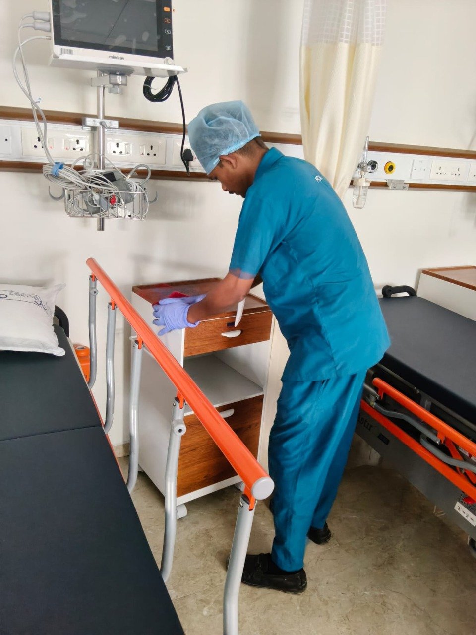 Patient care staff cleaning a hospital room