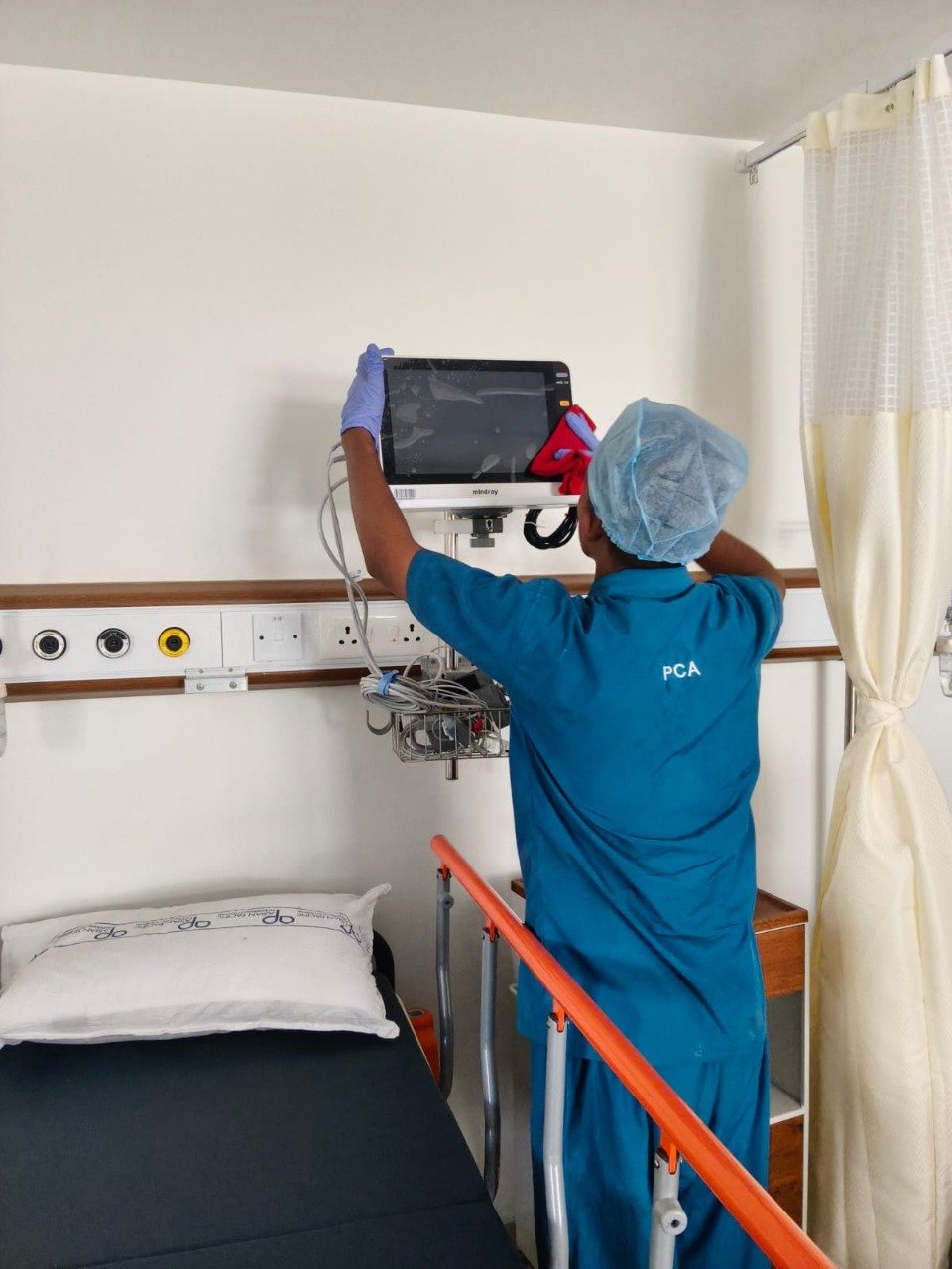 Staff sanitizing hospital monitor